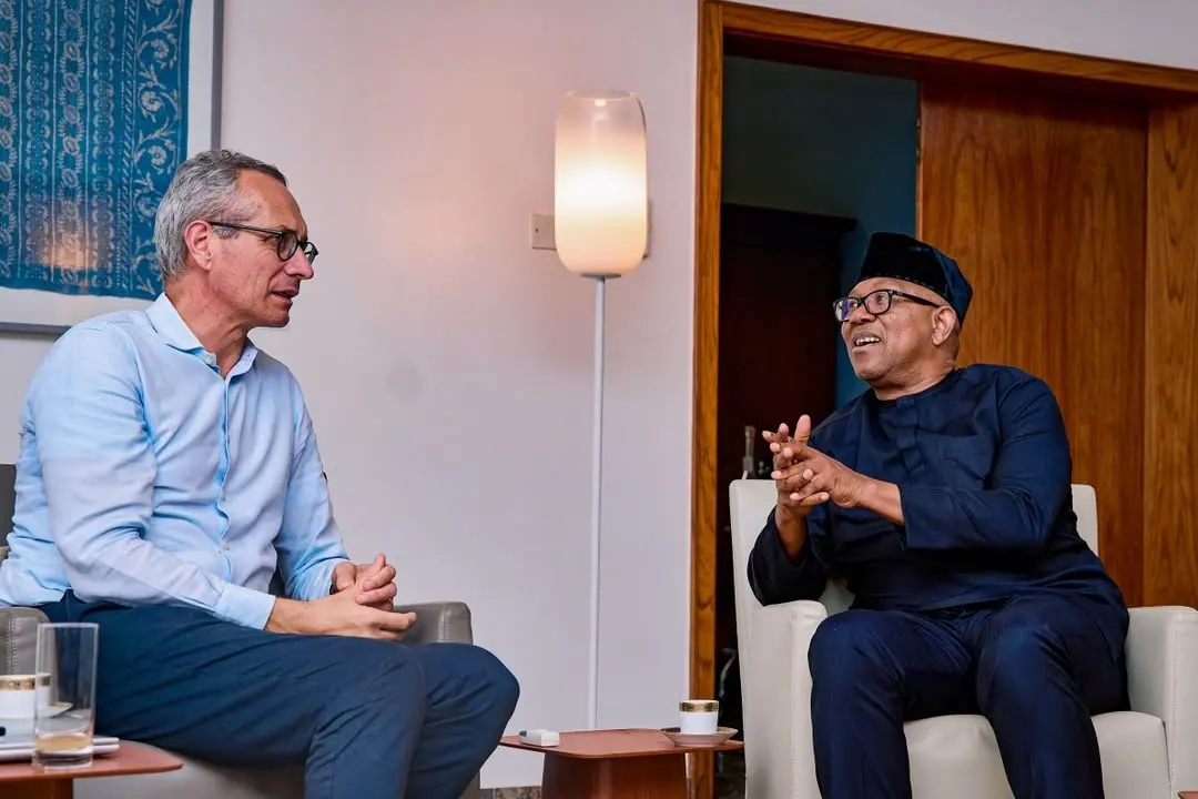 Peter Obi and a visitor talking and laughing in facing armchairs