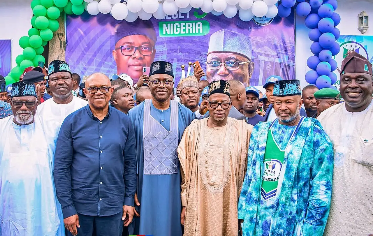 Peter Obi standing with a group of men under an arch of green, white and blue balloons