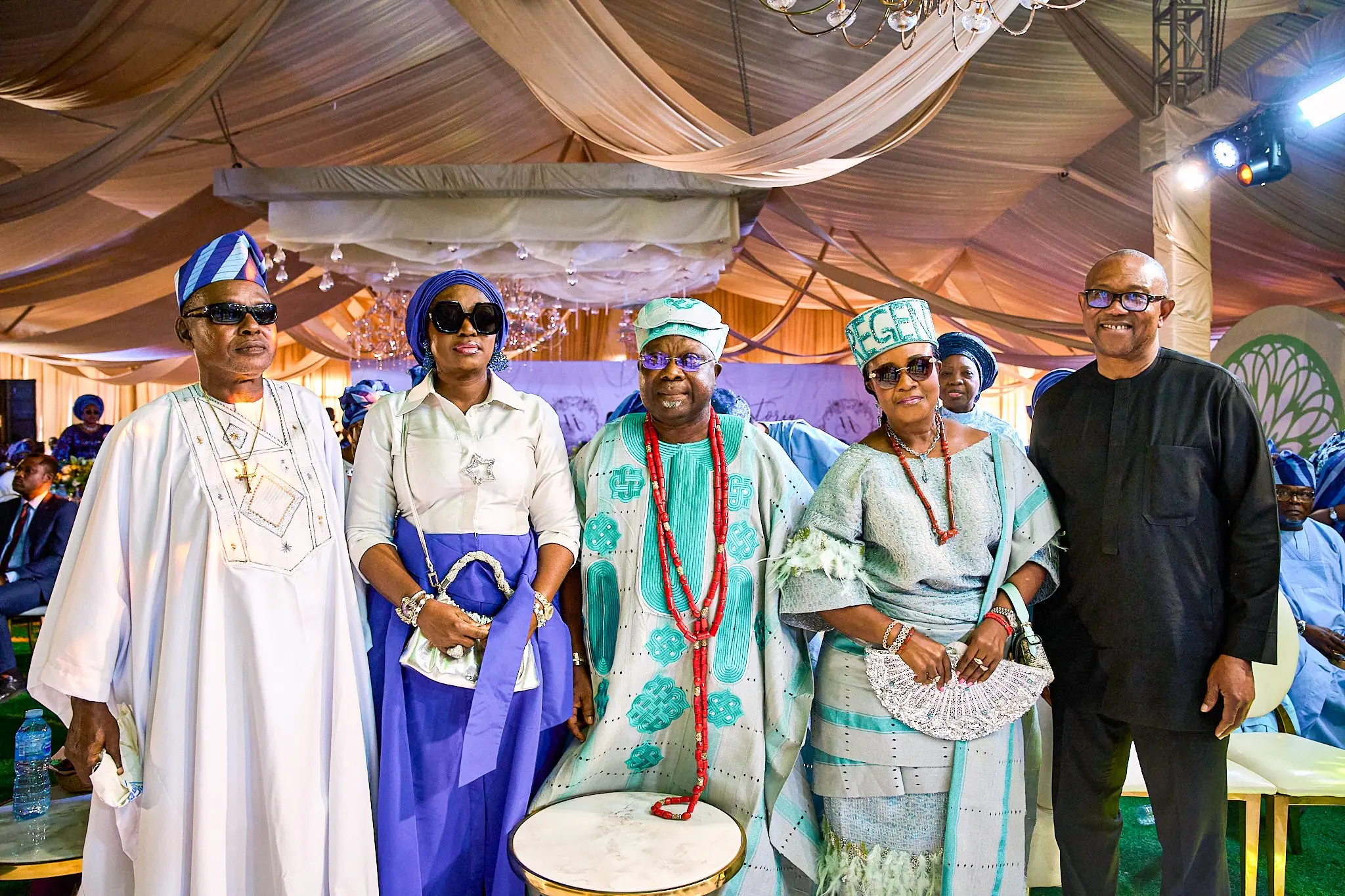 Peter Obi standing with a family in Yoruba ceremonial dress beside a talking drum