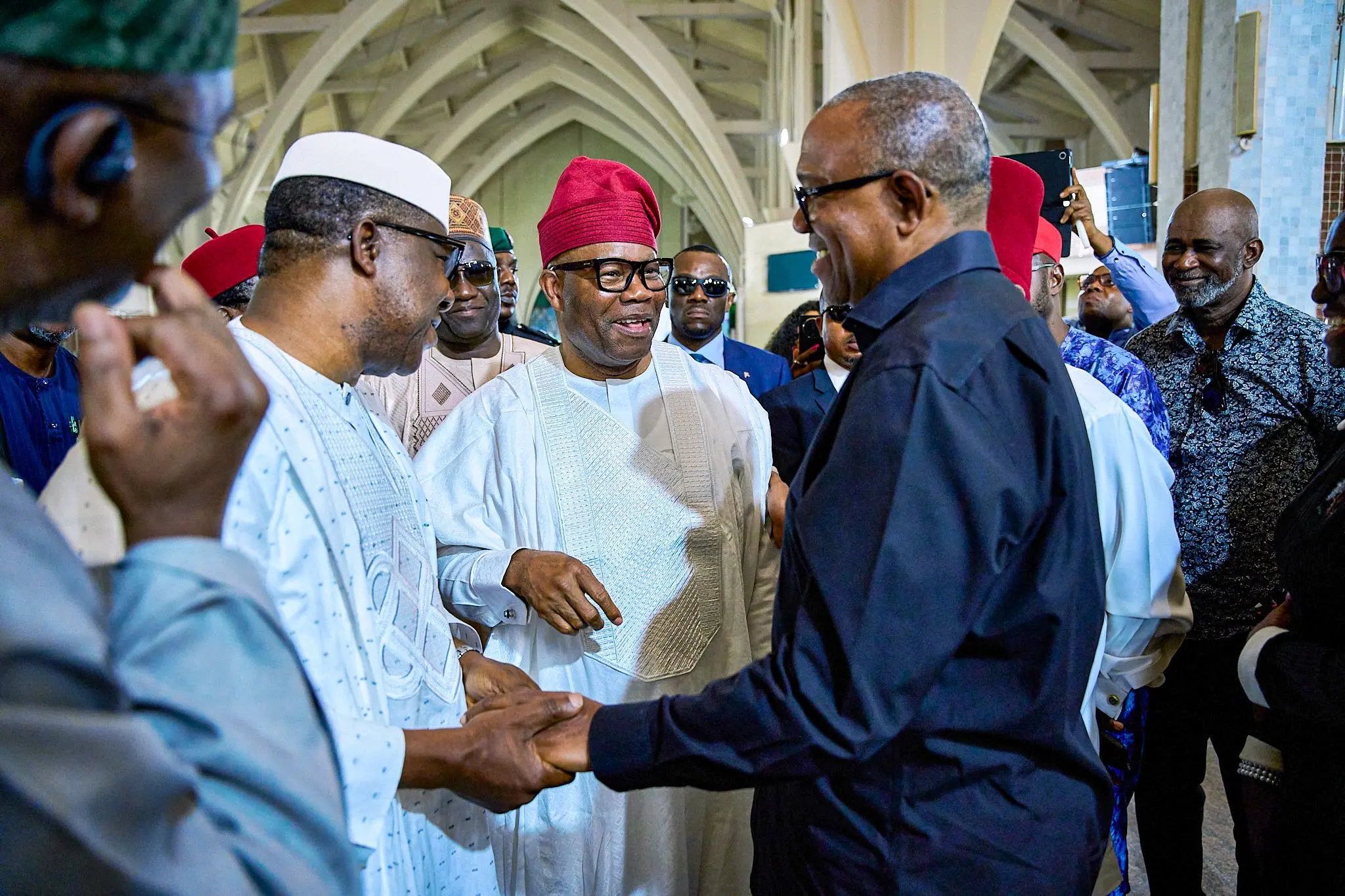 Peter Obi shaking hands with Senator Godswill Akpabio, Dr Ikem Ume-Ezeoke beside them, at a crowded ceremony