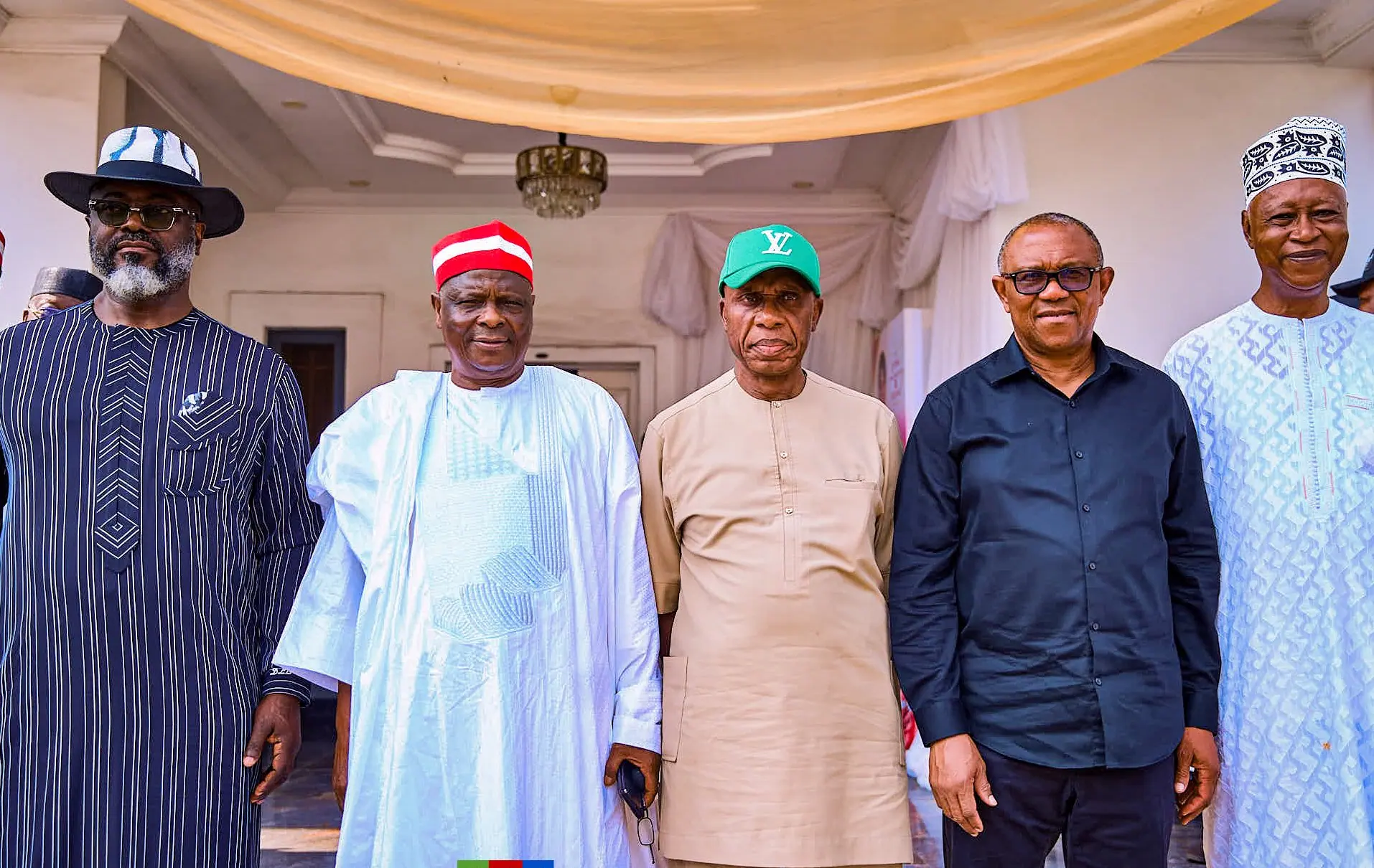 Peter Obi standing with four hosts in a reception room for a formal photograph