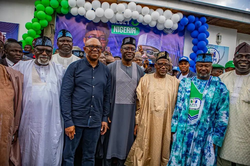 Peter Obi standing at the centre of a large group photograph of men in caps and agbada