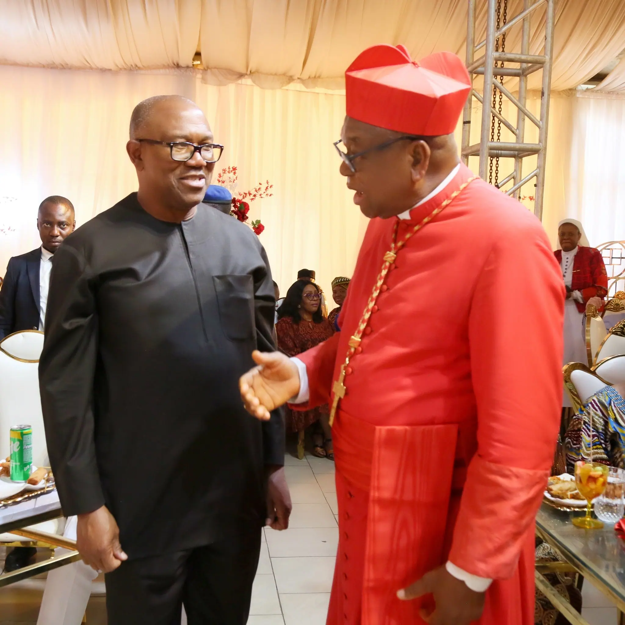 Peter Obi greeting Cardinal John Onaiyekan, in red robes and zucchetto, at a birthday celebration
