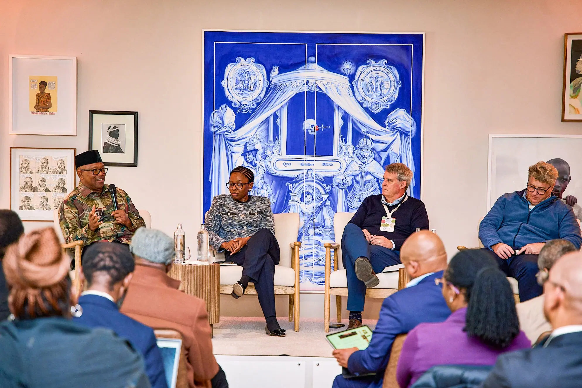 Peter Obi on a panel in front of a large blue mural, an audience seated in front