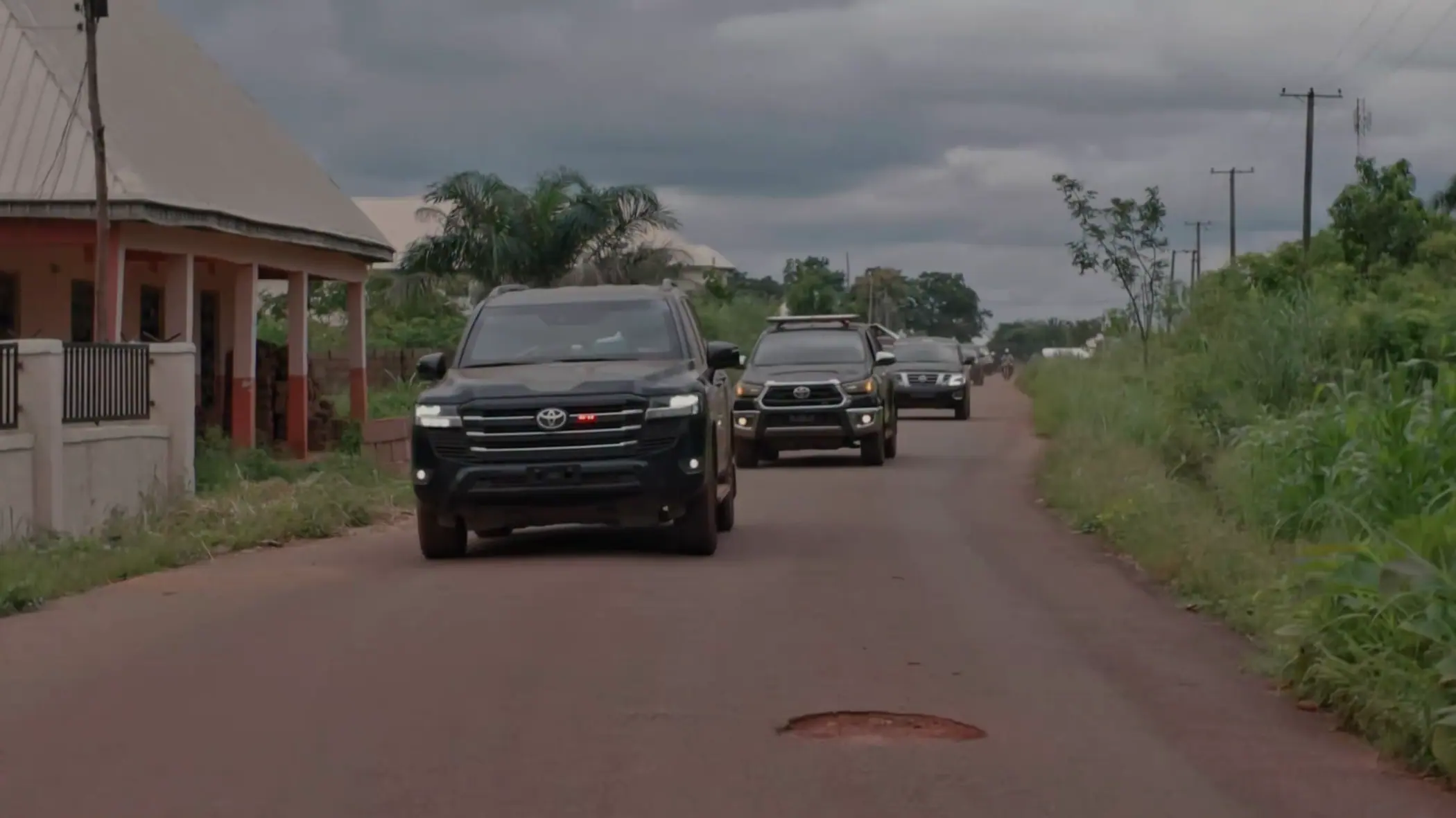 A small convoy of vehicles coming into a village in Benue State